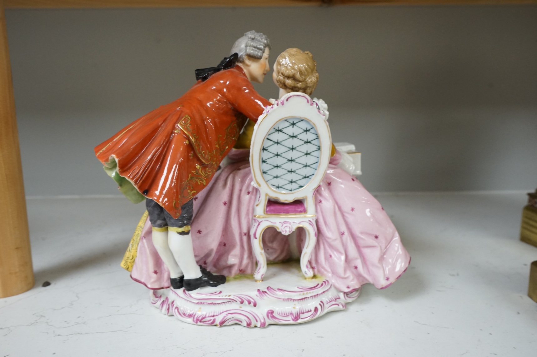 A large German porcelain group lovers at a piano, 22cm high